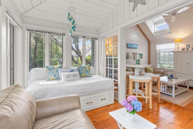 sunroom featuring a healthy amount of sunlight, vaulted ceiling with skylight, and ceiling fan