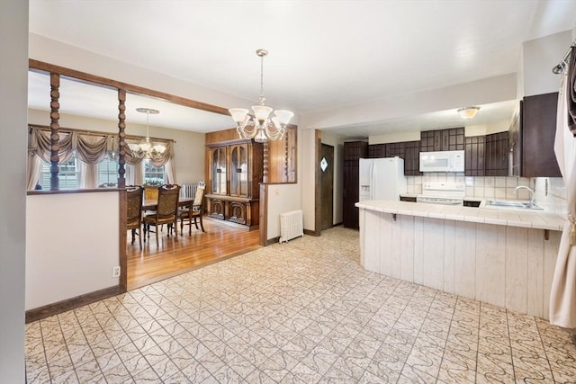 73 Biltmore St, Springfield, MA 01108 - kitchen featuring white appliances, a chandelier, radiator, dark brown cabinets, and tile counters