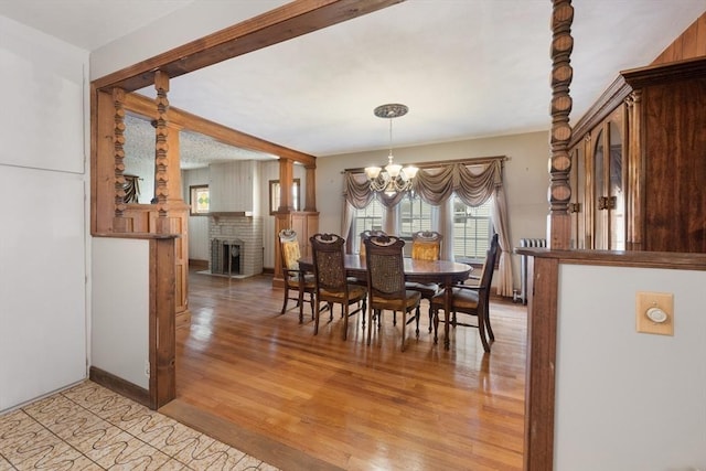 73 Biltmore St, Springfield, MA 01108 - dining area featuring light wood-style flooring, a chandelier, and a brick fireplace