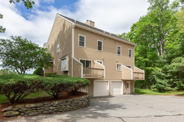 5 Brookfield Dr Unit B, Groton, MA 01450 - back of property featuring an attached garage, a chimney, and driveway