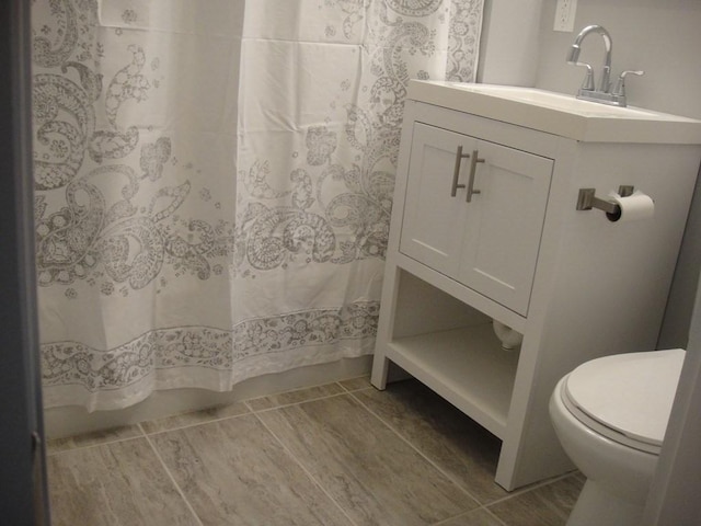 full bathroom with a shower with shower curtain, toilet, and vanity