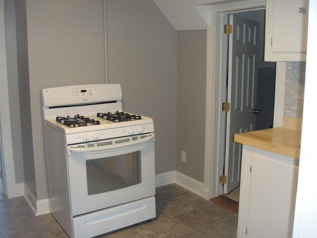 kitchen featuring white cabinets, light countertops, baseboards, and white gas range oven