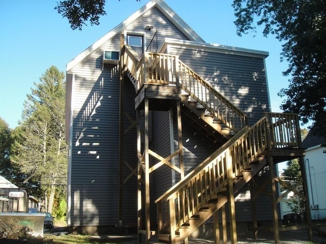 rear view of property featuring stairs and a deck