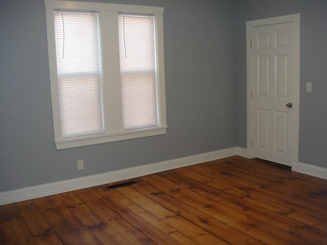 unfurnished room with visible vents, baseboards, and wood finished floors