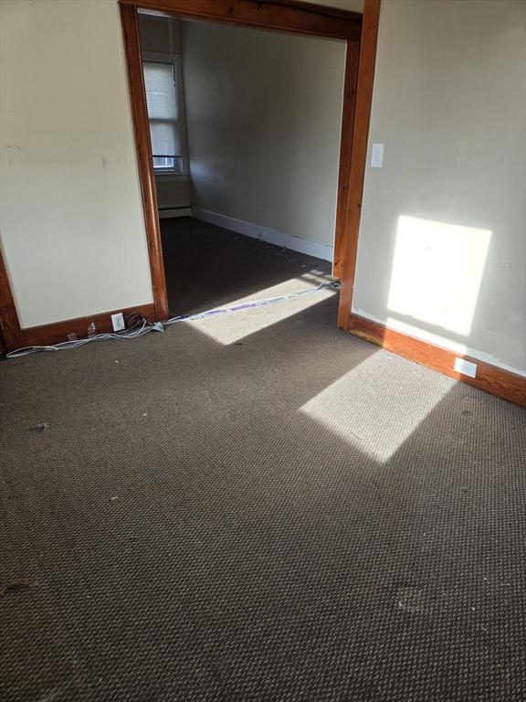 carpeted empty room with baseboard heating