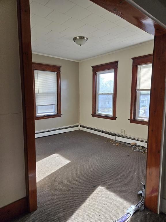 unfurnished room with carpet and crown molding