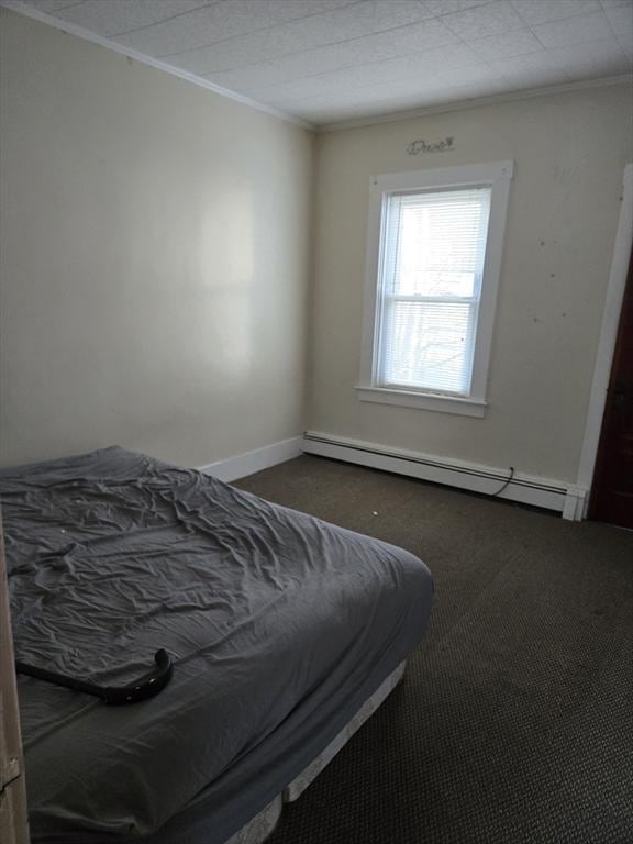 bedroom with baseboard heating and ornamental molding