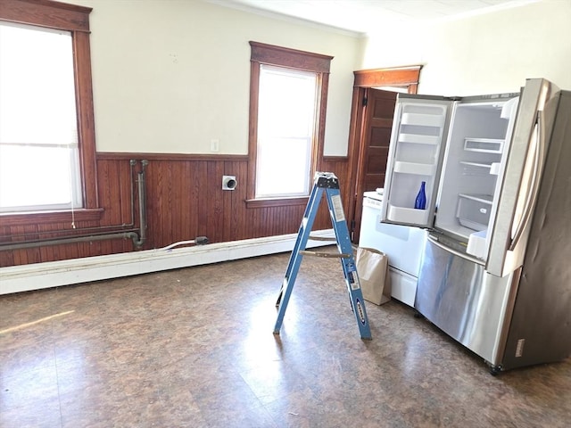 interior space featuring a wealth of natural light, wooden walls, and a baseboard heating unit