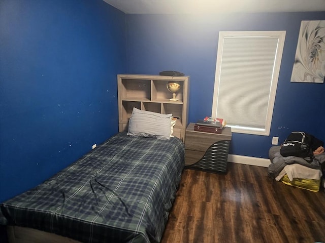 bedroom with dark hardwood / wood-style floors