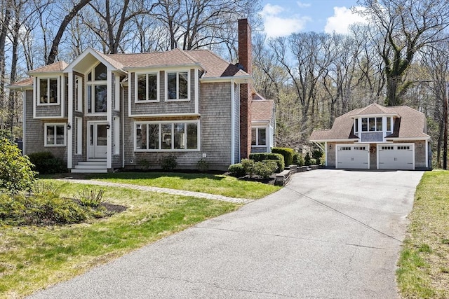 9 Lily Pond Ln, Cohasset, MA 02025 - view of front facade featuring a garage, a front lawn, driveway, and a chimney