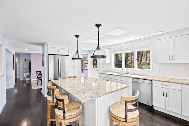 9 Lily Pond Ln, Cohasset, MA 02025 - kitchen with a sink, a center island, stainless steel appliances, and white cabinetry