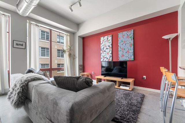 living room featuring concrete flooring and rail lighting