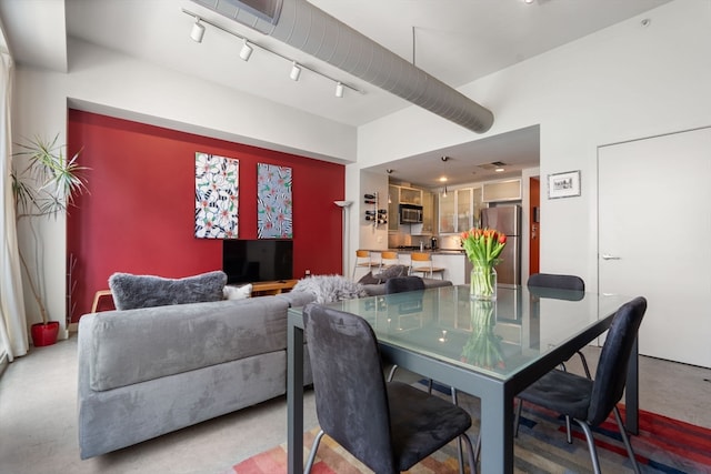 dining area featuring concrete flooring and rail lighting