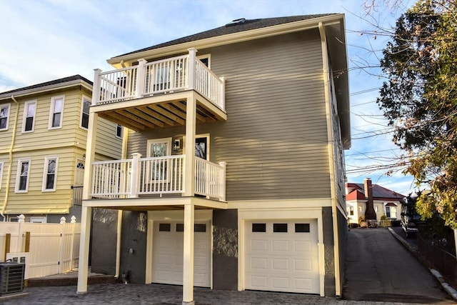 103-105 Neponset Ave, Boston, MA 02131 - back of property featuring a balcony, a garage, driveway, and stucco siding