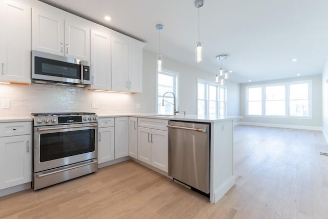 103-105 Neponset Ave, Boston, MA 02131 - kitchen with appliances with stainless steel finishes, light wood-style floors, healthy amount of natural light, a peninsula, and recessed lighting