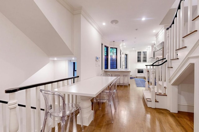 interior space with light hardwood / wood-style floors, sink, and crown molding