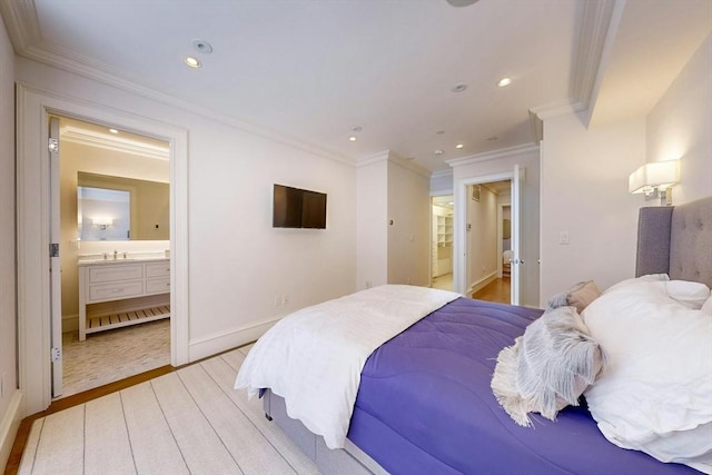 bedroom with sink, crown molding, light hardwood / wood-style flooring, and ensuite bath