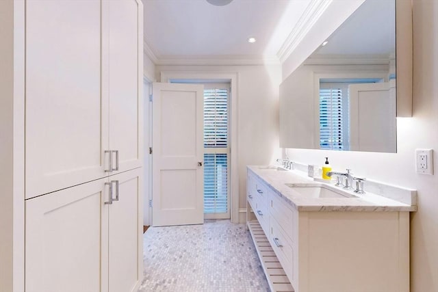 bathroom with tile patterned flooring, vanity, a healthy amount of sunlight, and ornamental molding