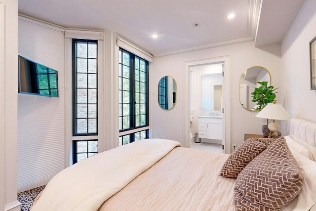 bedroom featuring ornamental molding, sink, and ensuite bath