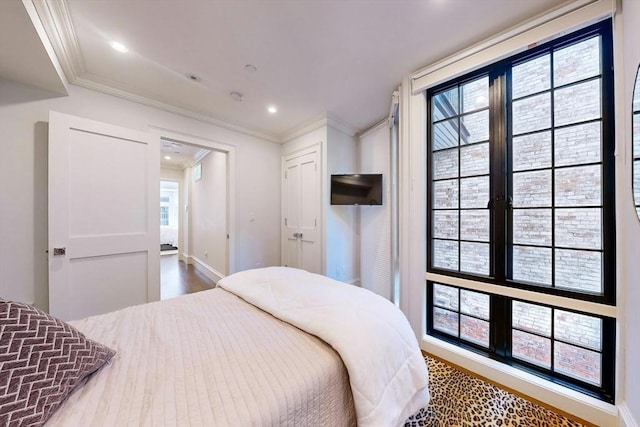 bedroom with hardwood / wood-style flooring and crown molding