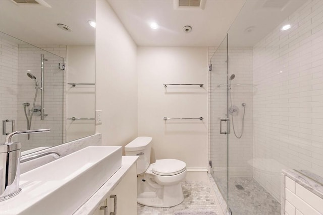 bathroom featuring tile patterned flooring, vanity, a shower with door, and toilet