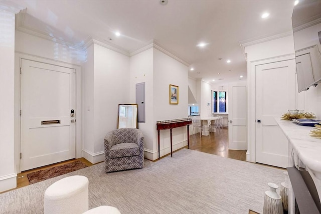 interior space featuring wood-type flooring, ornamental molding, and electric panel