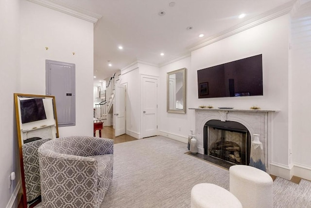 living room featuring electric panel, light hardwood / wood-style flooring, ornamental molding, and a premium fireplace