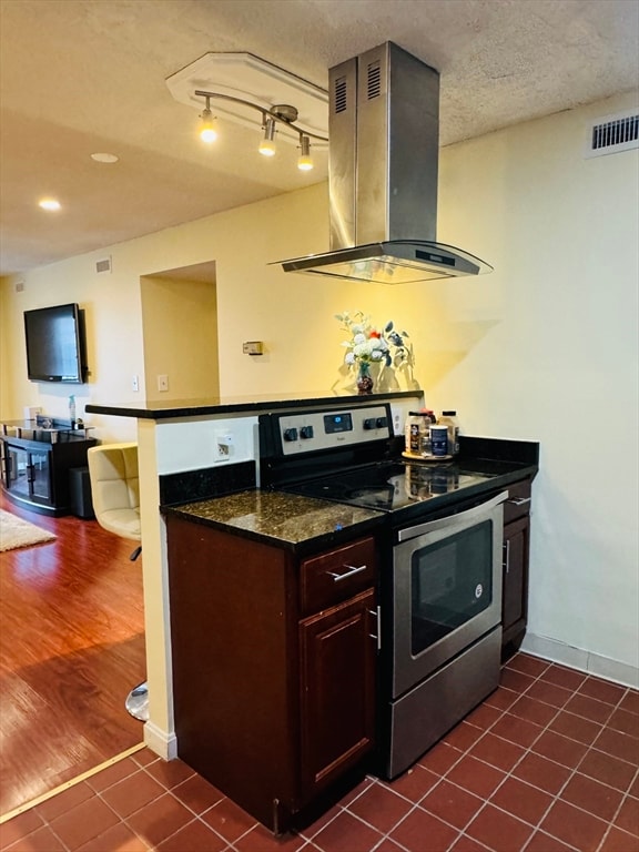 kitchen featuring dark tile patterned floors, electric range, exhaust hood, dark stone countertops, and a textured ceiling