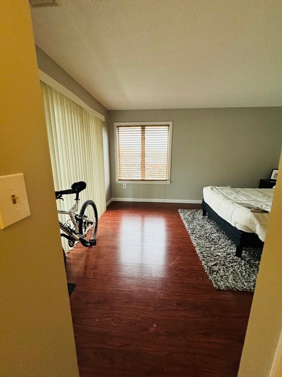 bedroom featuring dark hardwood / wood-style flooring and a textured ceiling