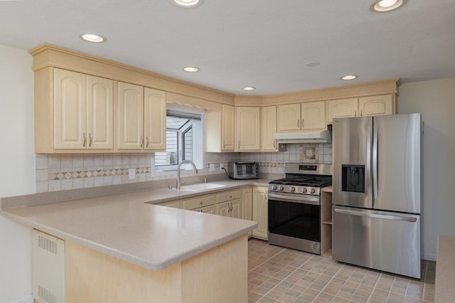 48 Rosemont St Unit 48, Haverhill, MA 01830 - kitchen with stainless steel appliances, a peninsula, under cabinet range hood, light countertops, and tasteful backsplash