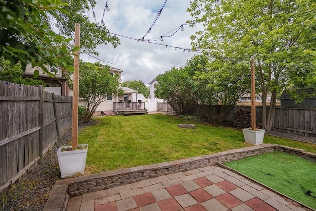 48 Rosemont St Unit 48, Haverhill, MA 01830 - fenced backyard with a wooden deck, a patio area, and an outdoor fire pit