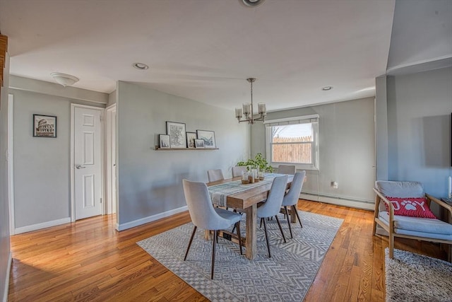 dining space featuring a notable chandelier, light hardwood / wood-style floors, and a baseboard radiator