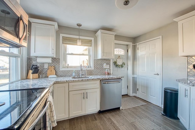 kitchen with decorative backsplash, sink, white cabinets, and appliances with stainless steel finishes