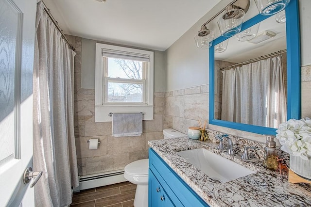 bathroom featuring a shower with curtain, vanity, a baseboard heating unit, tile walls, and toilet