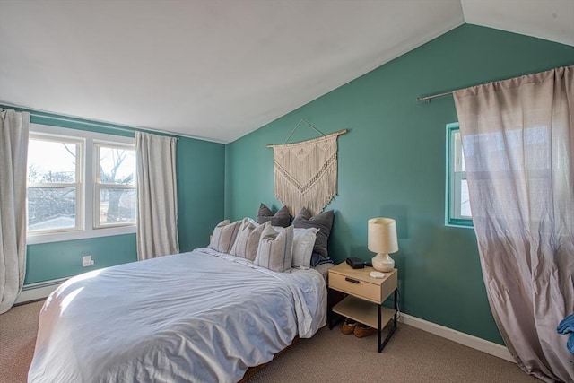 bedroom with a baseboard heating unit, light colored carpet, and vaulted ceiling