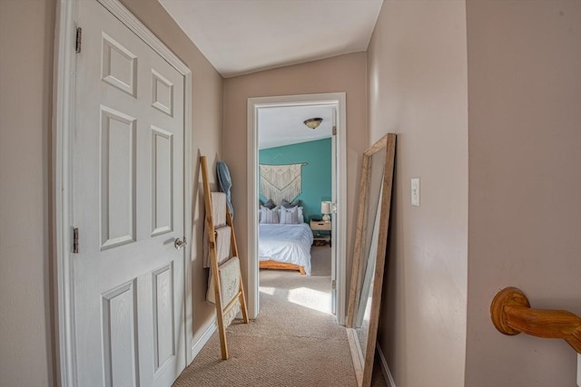 corridor featuring light carpet and lofted ceiling