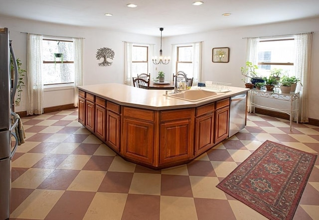 kitchen featuring an inviting chandelier, a center island with sink, sink, hanging light fixtures, and stainless steel appliances