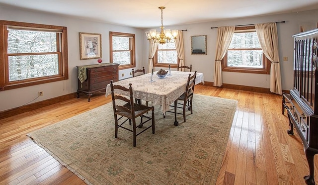 dining space featuring light hardwood / wood-style floors and a notable chandelier