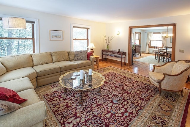 living room featuring a notable chandelier, plenty of natural light, and light hardwood / wood-style floors