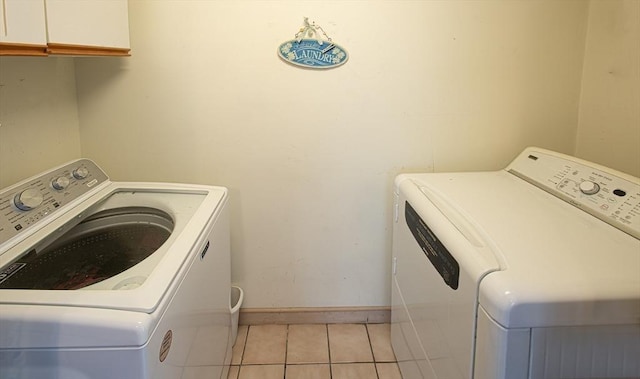 washroom featuring light tile patterned flooring, cabinets, and independent washer and dryer