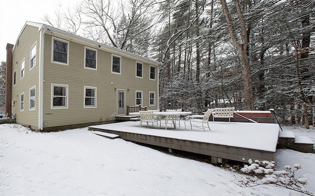 snow covered property with a wooden deck