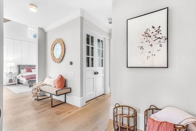 corridor featuring ornamental molding and light hardwood / wood-style flooring