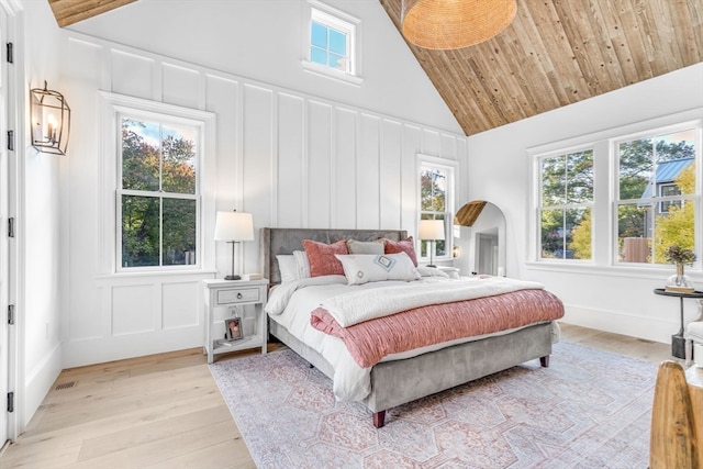 bedroom featuring light wood-type flooring and high vaulted ceiling