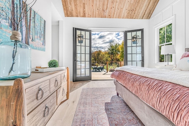 bedroom featuring access to exterior, lofted ceiling, wood ceiling, and light hardwood / wood-style floors