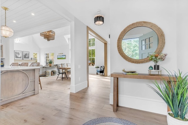 foyer entrance with vaulted ceiling with beams and light hardwood / wood-style floors