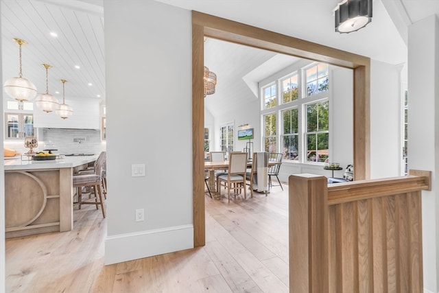 dining space featuring lofted ceiling and light hardwood / wood-style flooring