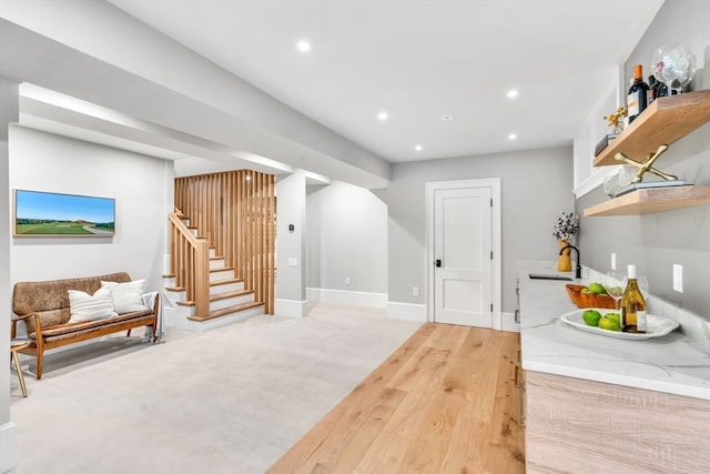 interior space featuring light stone countertops, sink, and light hardwood / wood-style flooring