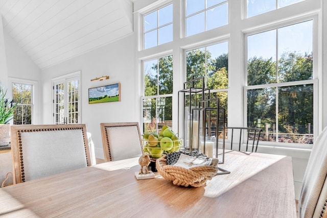 dining area with high vaulted ceiling and a healthy amount of sunlight