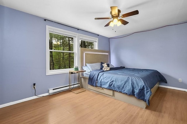 bedroom featuring a baseboard radiator, wood finished floors, baseboards, and a ceiling fan