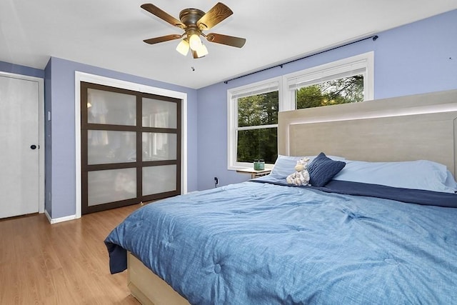 bedroom with wood finished floors, baseboards, and ceiling fan